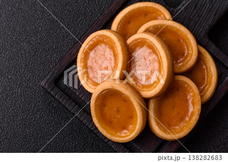 Round mini tartlets with citrus or peach jam and crumbly pastry. Mini citrus tarts 138282683