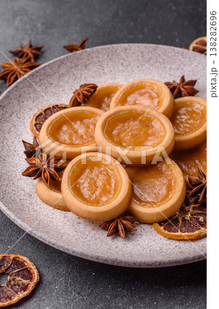 Round mini tartlets with citrus or peach jam and crumbly pastry. Mini citrus tarts Round mini tartlets with citrus or peach jam and crumbly pastry. Mini citrus tarts 138282696