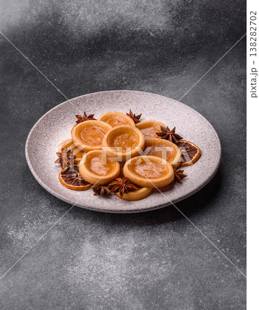 Round mini tartlets with citrus or peach jam and crumbly pastry. Mini citrus tarts 138282702