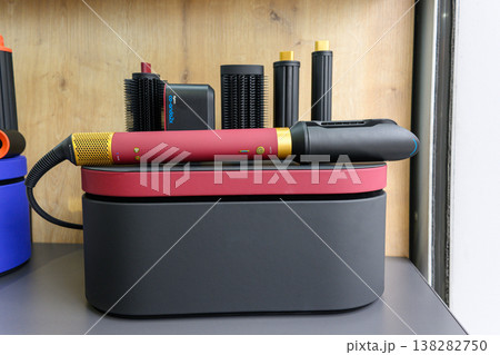 Red and black curling iron sits atop its case 138282750