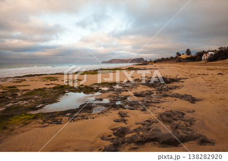 A rugged seascape with dark wet volcanic rocks, Porto Santo island, Portugal 138282920