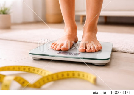 Feet on digital scale with measuring tape for weight loss concept 138283371