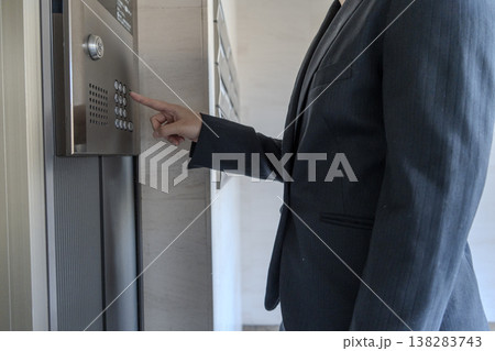 エレベーターのボタンを押す男性 138283743