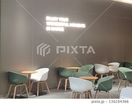 モダンなカフェ空間 壁面ロゴとシンプルなテーブル席 138284366