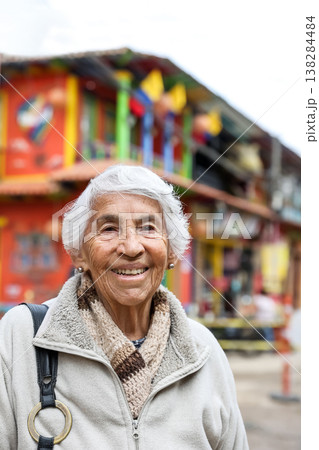 Happy senior lifestyle concept. Senior woman at the central square of the beautiful small town of Raquira. The city of pots in Colombia. Happy senior lifestyle concept. Senior woman at the central square of the beautiful small town of Raquira. The city of pots in Colombia. 138284484