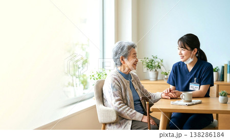 高齢女性に寄り添う介護スタッフのスキンシップと談笑 138286184