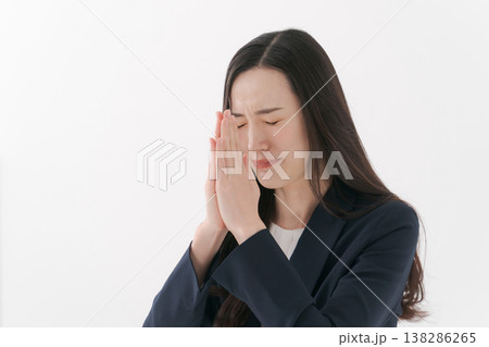手を合わせて祈るポーズをするスーツの女性 手を合わせて祈るポーズをするスーツの女性 138286265
