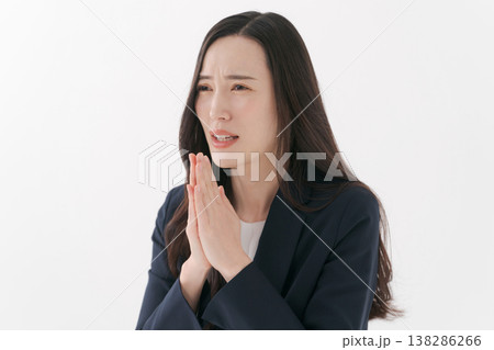 手を合わせて祈るポーズをするスーツの女性 138286266