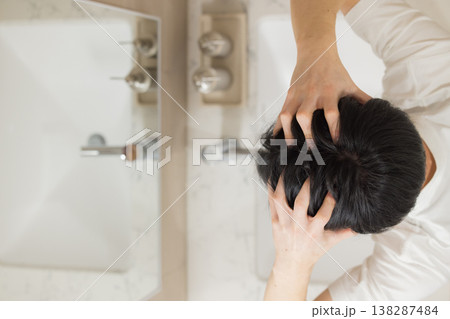 洗面所でヘアケアをする若い男性 洗面所でヘアケアをする若い男性 138287484
