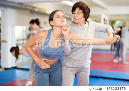 Female pupil clash with training manager during self-defense lesson, repulse charge, intensity of practice Female pupil clash with training manager during self-defense lesson, repulse charge, intensity of practice 138288176