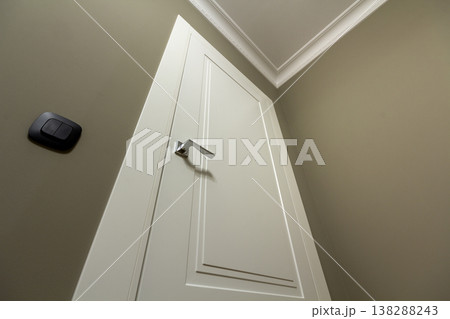 Apartment after renovation interior. White door with metal handle, light walls and ceiling, angle view. Apartment after renovation interior. White door with metal handle, light walls and ceiling, angle view. 138288243