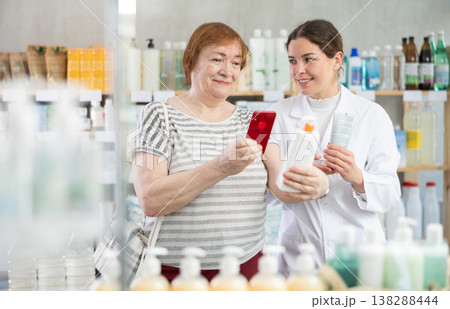 Woman buyer scans cream qr code with woman pharmacist 138288444