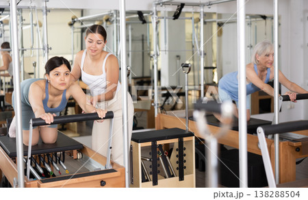 Young asian woman doing exercises on reformer with pilates instructor 138288504