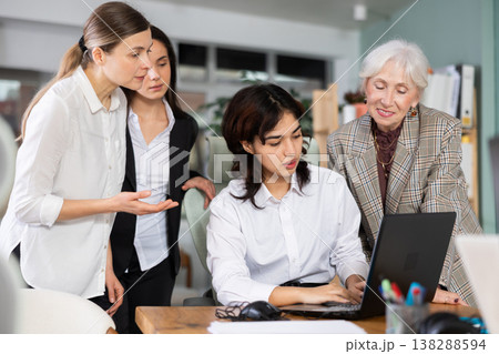 Group of women discussing work around laptop in office 138288594