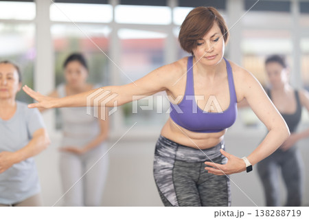 Group of women of different ages are learning various dance and ballet movements in studio Group of women of different ages are learning various dance and ballet movements in studio 138288719