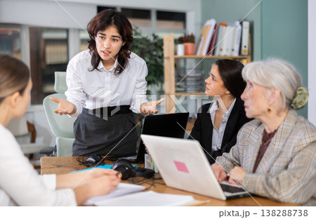 Standing Asian girl scold to round table gathering female staff at office Standing Asian girl scold to round table gathering female staff at office 138288738