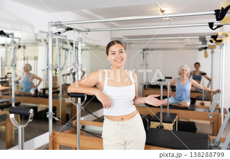 Friendly young female fitness instructor inviting to pilates studio 138288799