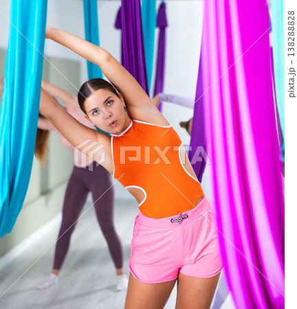 Young girls are warming up before doing aerial yoga Young girls are warming up before doing aerial yoga 138288828