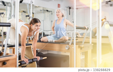 Young girl doing exercises on wunda chair in pilates studio Young girl doing exercises on wunda chair in pilates studio 138288829