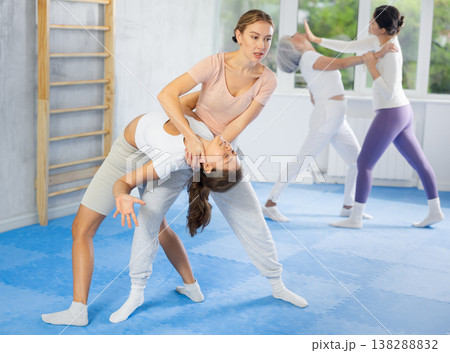 Women exercising armlock grip while sparring in sport gym Women exercising armlock grip while sparring in sport gym 138288832