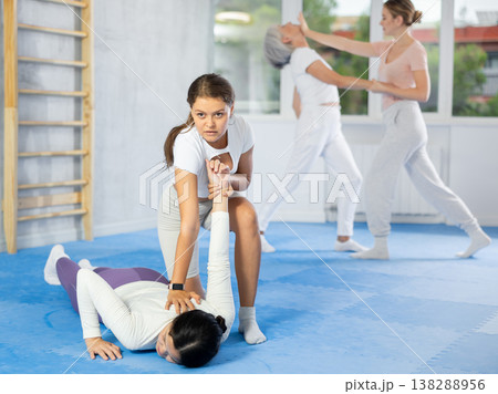 Young woman applying armlock to female opponent in simulated sparring during self-defense class Young woman applying armlock to female opponent in simulated sparring during self-defense class 138288956