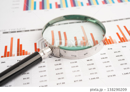 Magnifying glass on spreadsheet and graph paper. Magnifying glass on spreadsheet and graph paper. 138290209