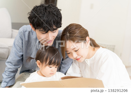 乳幼児に絵本の読み聞かせをする若い夫婦 乳幼児に絵本の読み聞かせをする若い夫婦 138291206