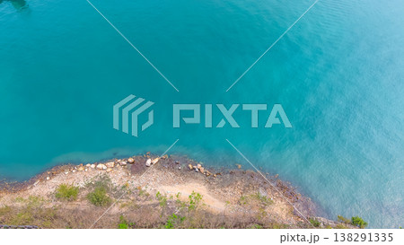 March 28 2026 Calm blue water meets curved strip of rocky coast. March 28 2026 Calm blue water meets curved strip of rocky coast. 138291335