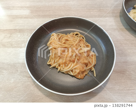 Spaghetti pasta creamy sauce plate lunch dinner homemade comfort food Italian cuisine delicious spaghetti lunch on brown plate with creamy tomato sauce on wooden table Spaghetti pasta creamy sauce plate lunch dinner homemade comfort food Italian cuisine delicious spaghetti lunch on brown plate with creamy tomato sauce on wooden table 138291744