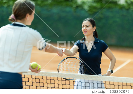 Adult woman tennis player shaking hands with her opponent Adult woman tennis player shaking hands with her opponent 138292073