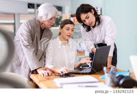 Female colleagues discussing project on laptop together 138292123