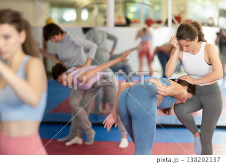 Women in pair perform effective impact on pain points while learning self-defense. 138292137