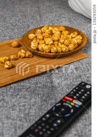 Snack time with popcorn and remote control on a couch Snack time with popcorn and remote control on a couch 138293059