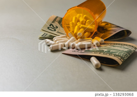 Cash and medicine spill on a table at night Cash and medicine spill on a table at night 138293068