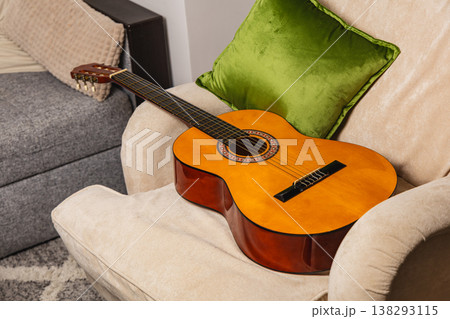 Guitar placed on sofa with green pillow in living room setting Guitar placed on sofa with green pillow in living room setting 138293115
