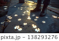 Enchanting glowing flower patterns illuminate a sidewalk at twilight, with a person standing nearby. 138293276