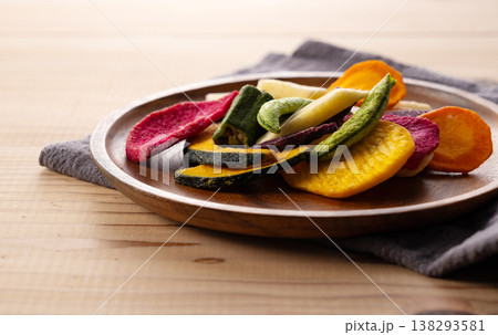 木製プレートと布のある食卓に盛られた色鮮やかな野菜チップス ライフスタイル 木製プレートと布のある食卓に盛られた色鮮やかな野菜チップス ライフスタイル 138293581