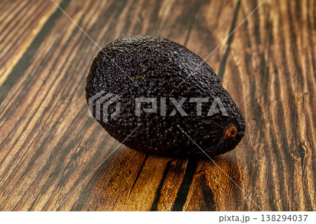 Whole ripe Hass avocados on a textured grey stone background. Whole ripe Hass avocados on a textured grey stone background. 138294037