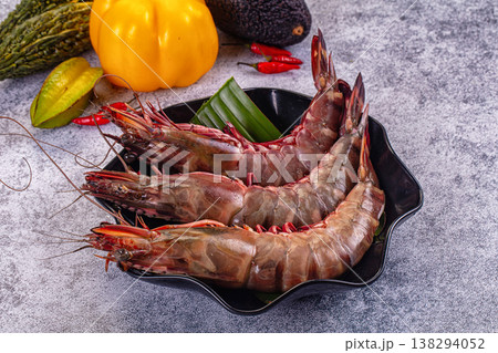 Fresh raw giant red prawns on a plate with chili peppers and tropical vegetables. 138294052