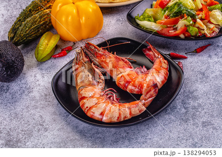 Grilled giant red prawns in a pan with fresh avocado, bell pepper, and salad on a stone table Grilled giant red prawns in a pan with fresh avocado, bell pepper, and salad on a stone table 138294053