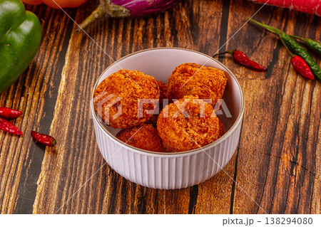 Golden fried cheese and vegetable balls, appetizer dish with fresh chili, peppers, and carrots on a wood table. Golden fried cheese and vegetable balls, appetizer dish with fresh chili, peppers, and carrots on a wood table. 138294080