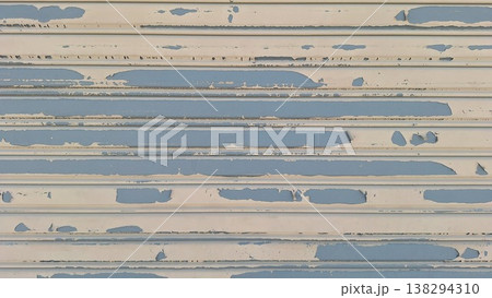 Grungy Texture of Peeling Beige Paint on Old Blue Metal Rolling Shutter Grungy Texture of Peeling Beige Paint on Old Blue Metal Rolling Shutter 138294310