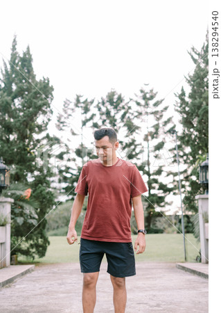 Southeast Asian man walking casually looking away in outdoor environment Southeast Asian man walking casually looking away in outdoor environment 138294540