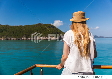Young woman standing on boat deck and looking at tropical islands in Ang Thong marine park Thailand Young woman standing on boat deck and looking at tropical islands in Ang Thong marine park Thailand 138295986