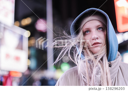 Teenage girl portrait at Times Square New York at night, young woman in hooded winter jacket with wind blowing hair under bright neon city lights Teenage girl portrait at Times Square New York at night, young woman in hooded winter jacket with wind blowing hair under bright neon city lights 138296203