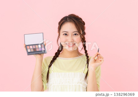 アイシャドウパレットを持つ若い女性 138296369