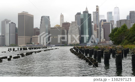 Manhattan downtown skyline from Brooklyn Bridge Park, New York City, USA. Skyscrapers, old pier pile Manhattan downtown skyline from Brooklyn Bridge Park, New York City, USA. Skyscrapers, old pier pile 138297125
