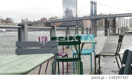 Manhattan Bridge, Brooklyn Bridge park, New York City Dumbo, USA. Waterfront chairs and tables, rain Manhattan Bridge, Brooklyn Bridge park, New York City Dumbo, USA. Waterfront chairs and tables, rain 138297387