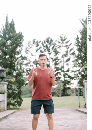 Southeast Asian man showing finger gesture with thumb and index finger outdoors 138298093