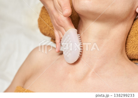Young Caucasian Female Receiving Neck Massage With Exfoliating Brush For Skin Care And Relaxation Young Caucasian Female Receiving Neck Massage With Exfoliating Brush For Skin Care And Relaxation 138299233